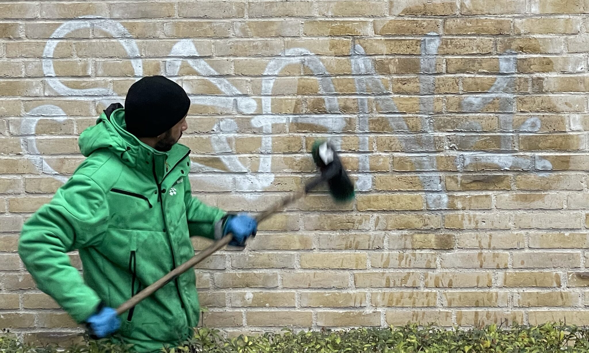 Skånsom fjernelse af graffiti, hvor det korrekte middel bliver skrubbet på graffitien